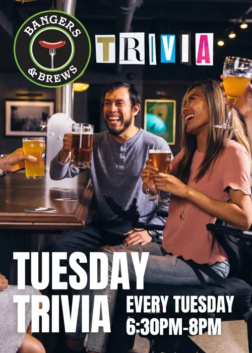People enjoying trivia night, laughing and clinking beer glasses in a bar setting.